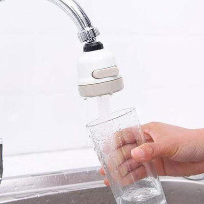 Hand holding white faucet aerator over sink, with water flowing from the outlet