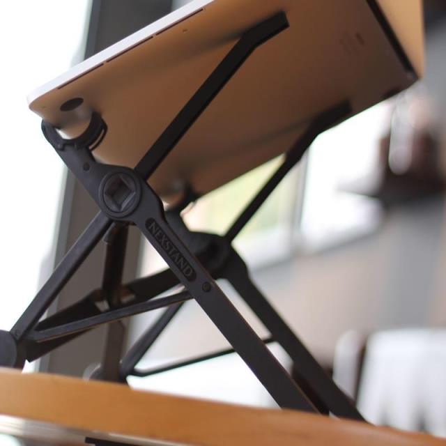 Close-up of black adjustable laptop stand clamp and support arms