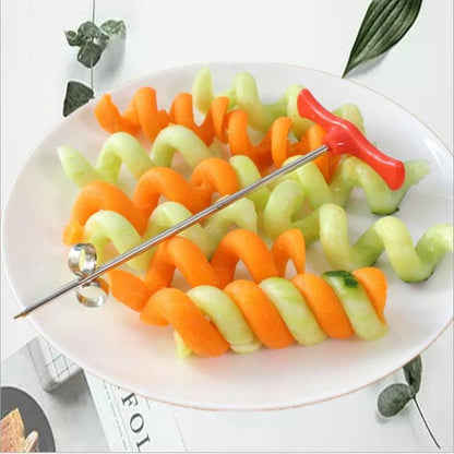 Spiral potato cutter tool resting on a bowl of green and orange spiraled vegetable slices