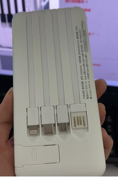 White portable power bank with multiple charging ports and label on the back panel.