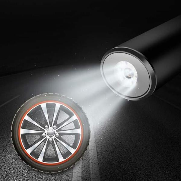Mini tire air pump nozzle emitting airflow toward an alloy wheel