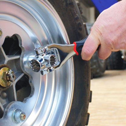 Universal socket wrench on wheel axle area with chrome head and red-black grip