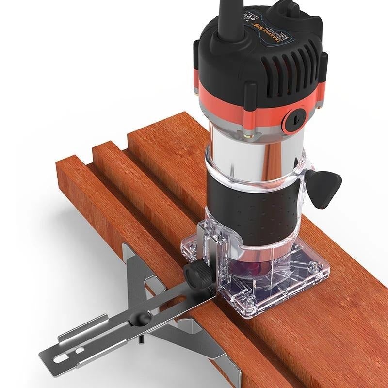 Handheld trim router with transparent base cutting wood edge, black and red housing