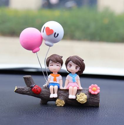 Couple car decoration figurines holding heart balloon on dark wood base