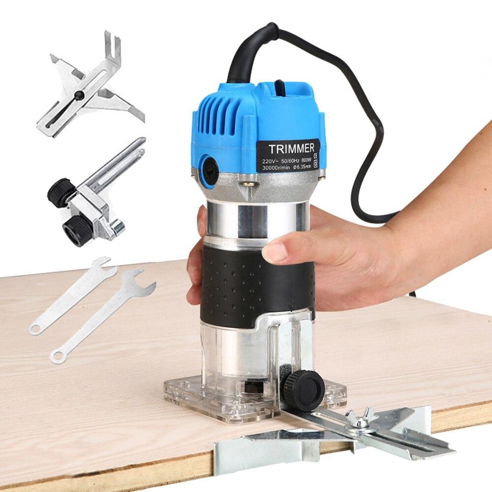 Trim router held in hand cutting along wood edge, blue motor and transparent base